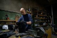 Vadim Mirnichenko prépare des plaques de métal qui serviront à fabriquer des protections pare-balles, le 1er mai 2022 dans son atelier de Zaporijjia, en Ukraine (AFP/Ed JONES)