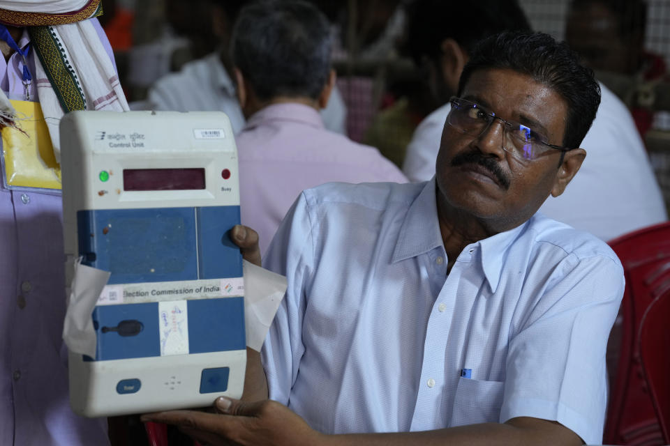 An election official displays an electronic voting machine after unsealing it to count votes at a counting center in Lucknow , India, Tuesday, June 4, 2024. India on Tuesday started counting votes from its staggered, six-week election that was seen as a referendum on Prime Minister Narendra Modi's decade in power and was expected to give him a third term in office. (AP Photo/Rajesh Kumar Singh)