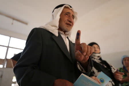 A man shows his ink-stained finger after casting his ballot in Qamishli, Syria September 22, 2017. REUTERS/Rodi Said