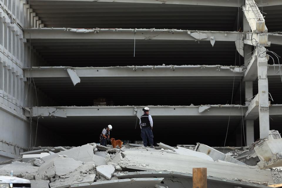 DORAL, FL - OCTOBER 10: Miami-Dade Fire Rescue search and rescue workers search in the rubble of a four-story parking garage that was under construction and collapsed at the Miami Dade College’s West Campus on October 10, 2012 in Doral, Florida. Early reports indicate one person was killed in the collapse at least seven people injured and one is still trapped. (Photo by Joe Raedle/Getty Images)