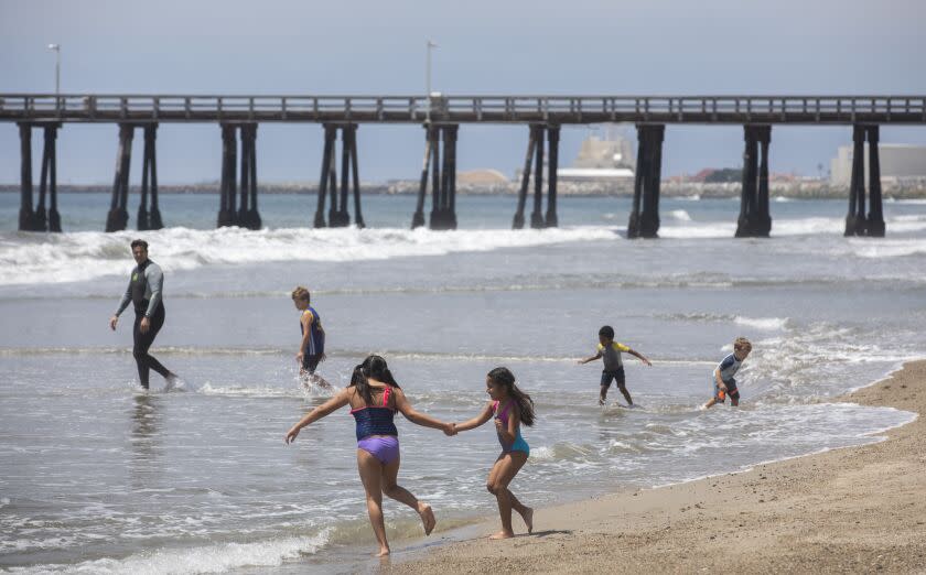 4PORT HUENEME, CA-APRIL 30, 2020: Avina Stone, 8, foreground, left, plays on the shoreline with her sister Sofia, 7, near the pier at Port Hueneme Beach. (Mel Melcon/Los Angeles Times)