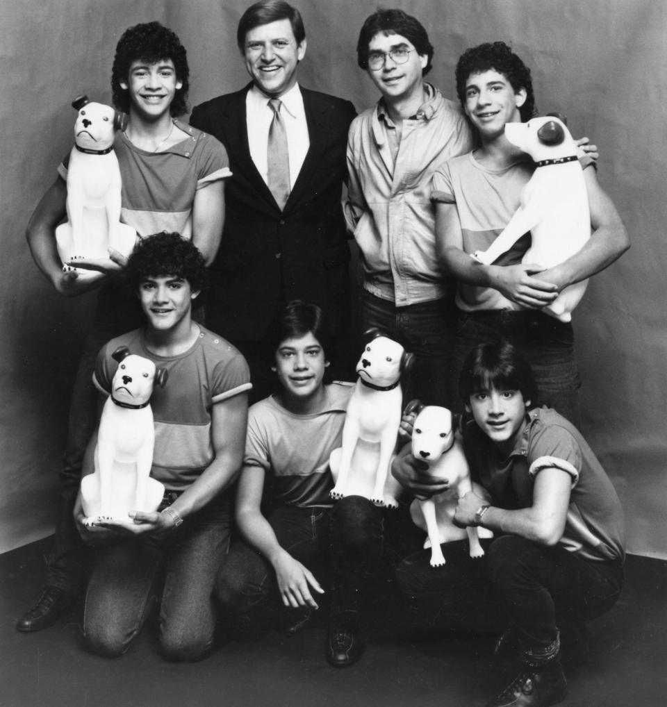 Jose Menendez, top row, second from left, is pictured with former members of Menudo in 1983, including Roy Rossello, bottom right. Also pictured is the band's one-time manager, Edgardo Diaz, top row, second from right. / Credit: Sony Music/RCA Records