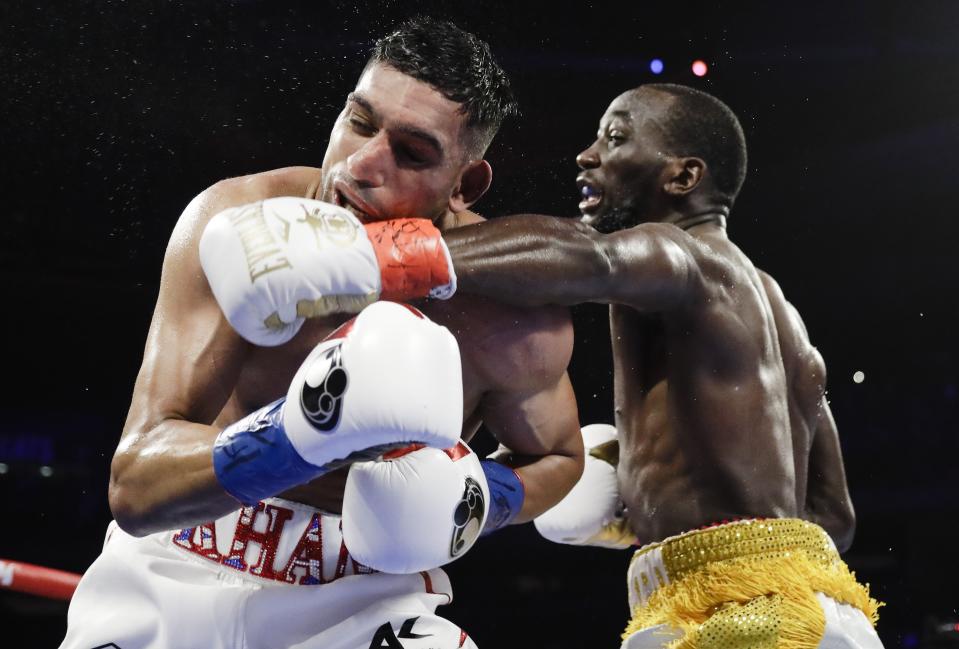 Terence Crawford, right, punches England's Amir Khan during the fifth round of a WBO world welterweight championship boxing match Sunday, April 21, 2019, in New York. Crawford won the fight. (AP Photo/Frank Franklin II)