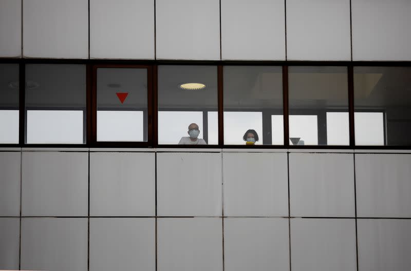 People wearing protective face masks look outside from a building of Kawakita General Hospital during the outbreak of the coronavirus disease (COVID-19) in Tokyo
