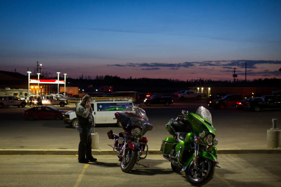 Ron Laybolt calls family from a parking lot in Conklin, Alberta, after Fort McMurray was evacuated May 3, 2016. REUTERS/Topher Seguin