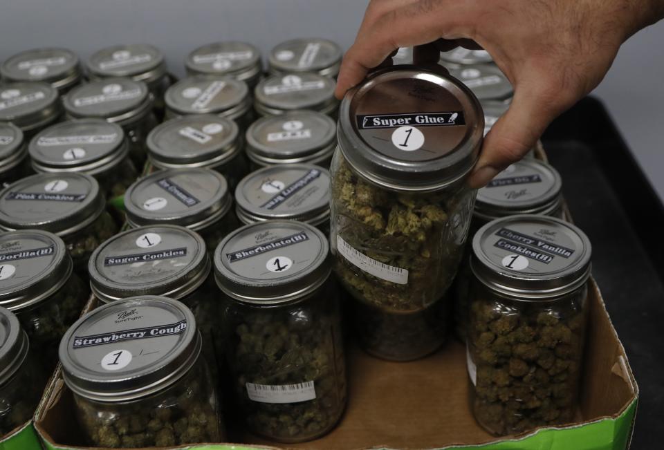 An attendant holds a mason jar of marijuana at a dispensary in Detroit, Michigan, where recreational marijuana has been legalized. Utah's law won't allow people with prescriptions to smoke the drug&nbsp;but they can obtain it in pill form or oils. (Photo: ASSOCIATED PRESS)