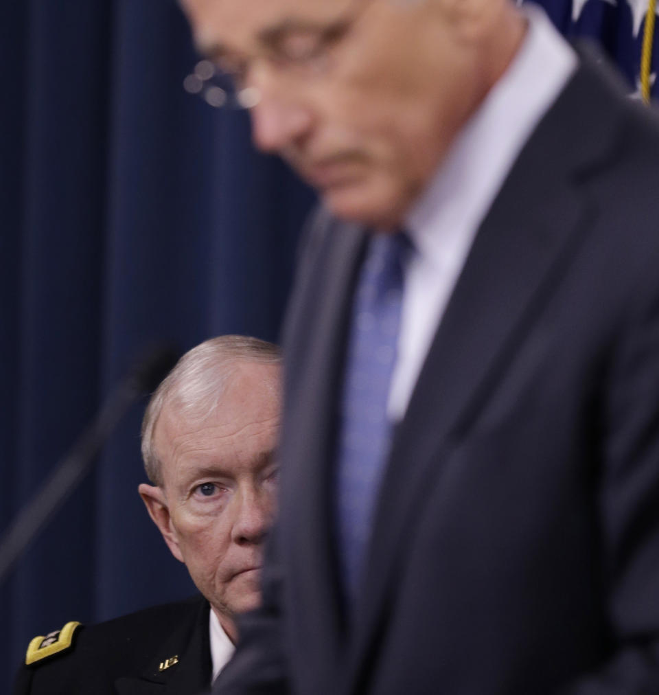 Joint Chiefs Chairman Gen. Martin Dempsey listens at left as Defense Secretary Chuck Hagel briefs reporters at the Pentagon, Monday, Feb. 24, 2014, where he recommended shrinking the Army to its smallest size since the buildup to U.S. involvement in World War II in an effort to balance postwar defense needs with budget realities. (AP Photo/Carolyn Kaster)