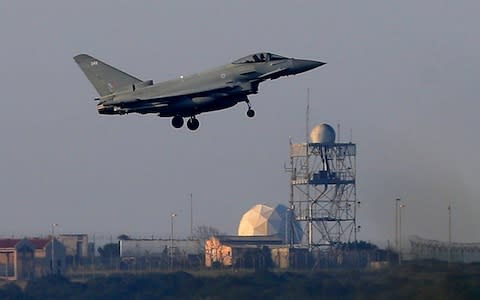 A Typhoon aircraft prepares for landing at the British Royal Air Force base in Akrotiri, near costal city of Limassol in the eastern Mediterranean island of Cyprus, early Saturday, April 14, 2018. Syria's capital has been rocked by loud explosions that lit up the sky with heavy smoke as U.S. President Donald Trump announced airstrikes in retaliation for the country's alleged use of chemical weapons. - Credit: Petros Karadjias/AP