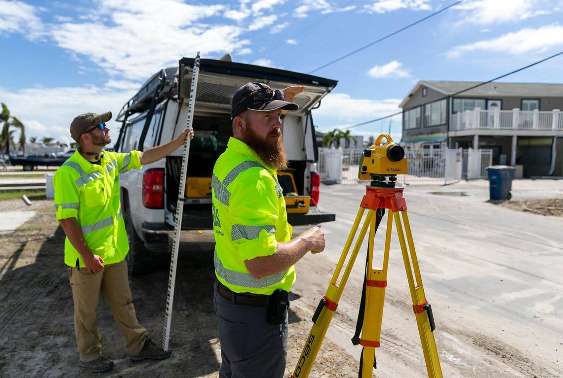 James Fountain, 40, right, and David Hough, 30, with the U.S. Geological Survey, discuss their mission to track storm surge watermarks on Tuesday, Oct. 18, 2022, in Fort Myers Beach, Florida.
