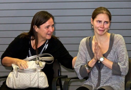 Amanda Knox (R) acknowledges the cheers of supporters while her mother Edda Mellas comforts her in Seattle, Washington. A tearful Knox arrived home in the US and thanked her supporters a day after she was acquitted of murder and sexual assault charges, ending a four-year ordeal in an Italian jail