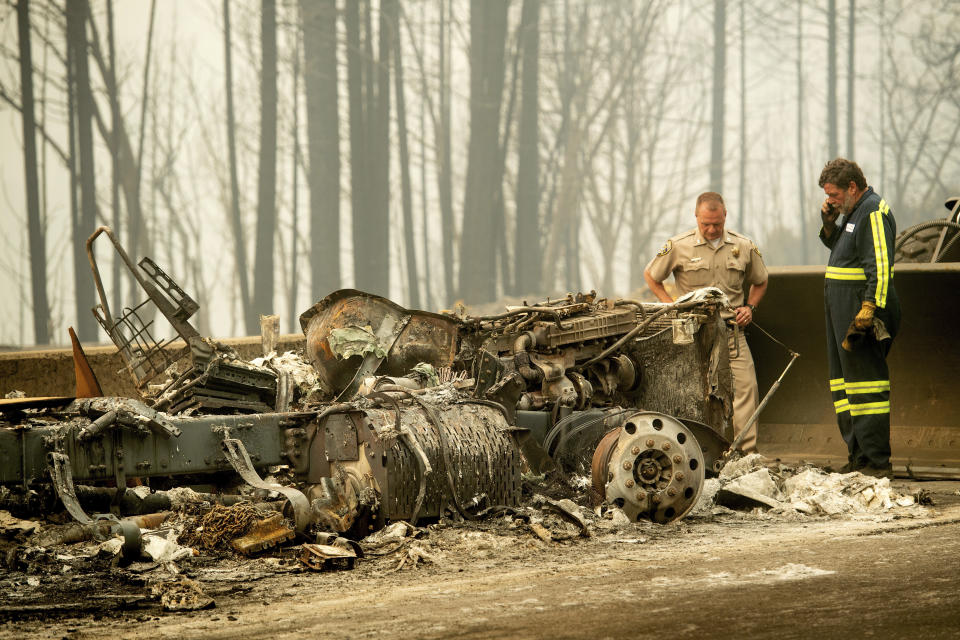 California Capt. Mark Loveless examines a truck scorched by the Delta Fire burning along Interstate 5 in the Shasta-Trinity National Forest, Calif., on Thursday, Sept. 6, 2018. The highway remains closed to traffic in both directions as crews battle the blaze. (AP Photo/Noah Berger)