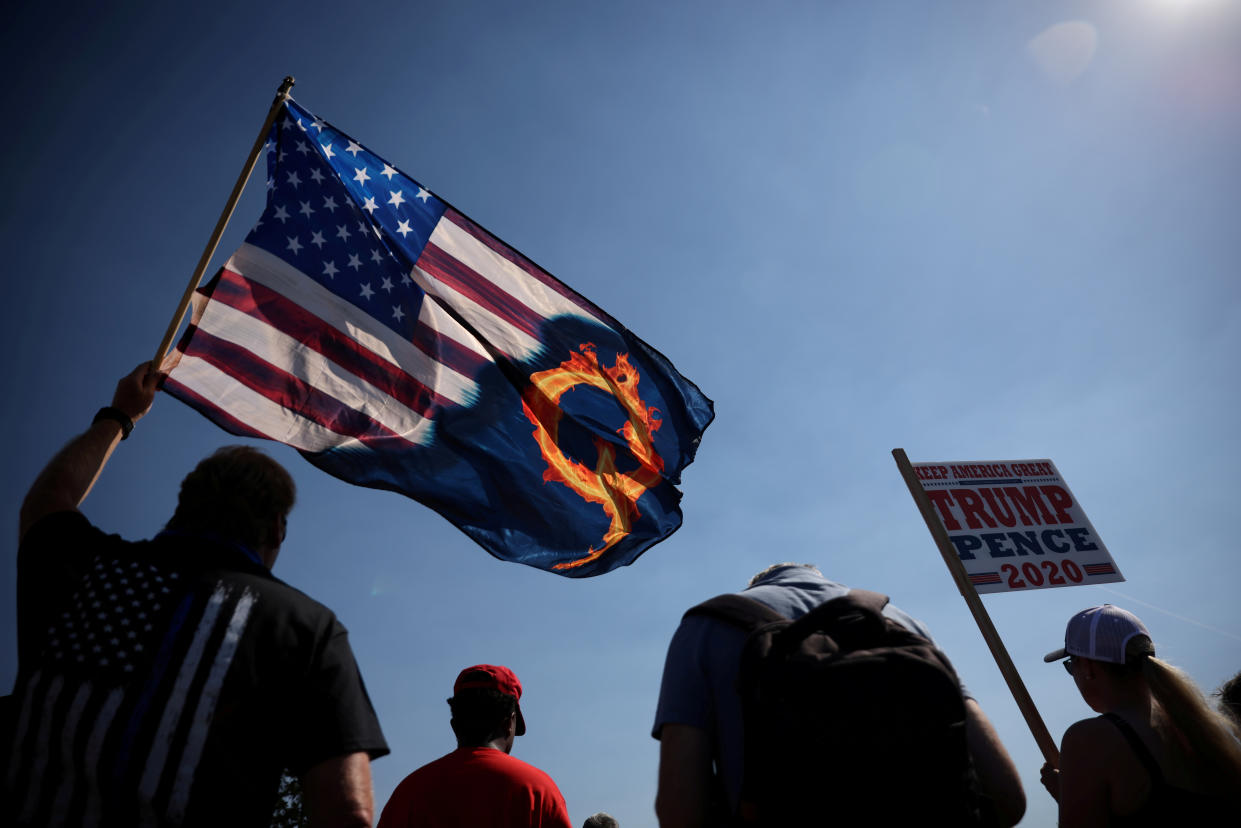 A supporter of President Donald Trump holds an U.S. flag with a reference to QAnon during a Trump 2020 Labor Day cruise rally in Oregon city, Oregon on September 7, 2020. (Carlos Barria/Reuters)