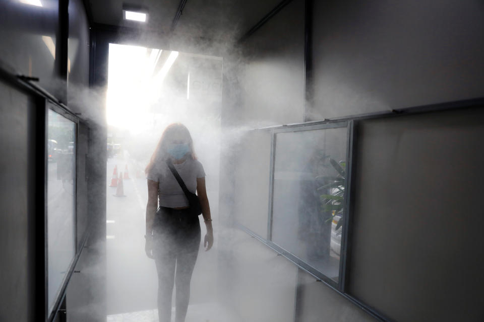 A woman wearing a mask passes through a sanitisation tunnel at a mall as India eases lockdown restrictions that were imposed to slow the spread of the coronavirus disease (COVID-19), in New Delhi, India, June 8, 2020. REUTERS/Anushree Fadnavis