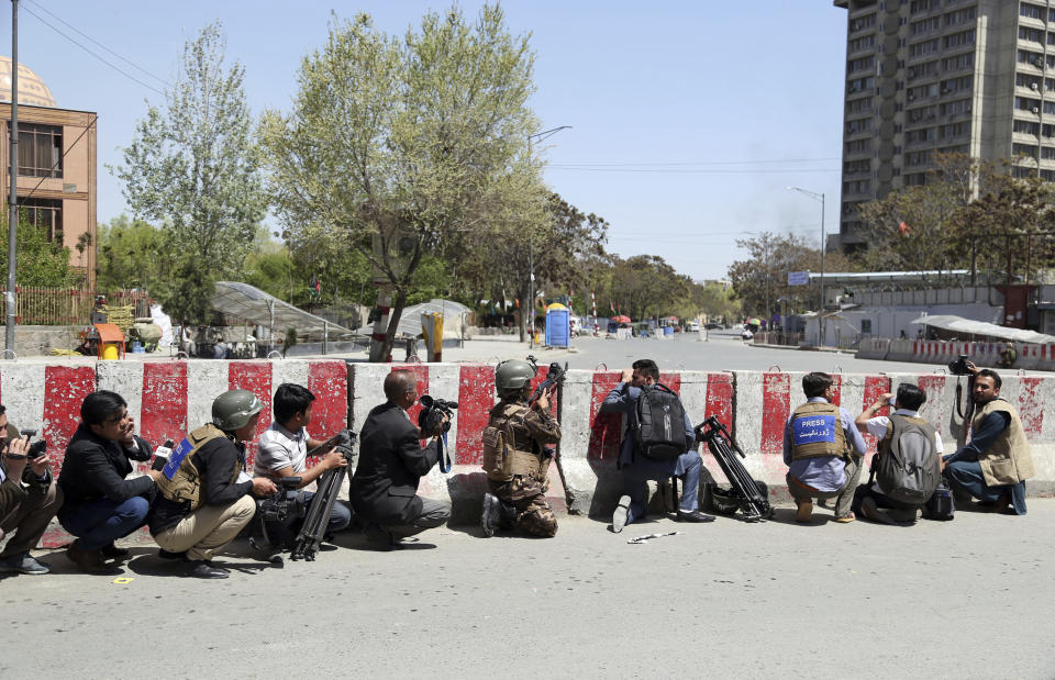 An Afghan Security personnel, center, take positions on the perimeter outside the Telecommunication Ministry during a gunfight with insurgents in Kabul, Afghanistan, Saturday, April 20, 2019. Afghan officials say an explosion has rocked the telecommunications ministry in the capital city of Kabul. Nasart Rahimi, a spokesman for the interior ministry, said Saturday the blast occurred during a shootout with security forces. (AP Photo/Rahmat Gul)