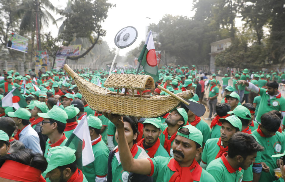 A supporter of the Awami League political party holds a miniature boat, the party's election icon, as they gather to attend a rally celebrating the overwhelming victory in last month's election in Dhaka, Bangladesh, Saturday, Jan. 19, 2019. (AP Photo)