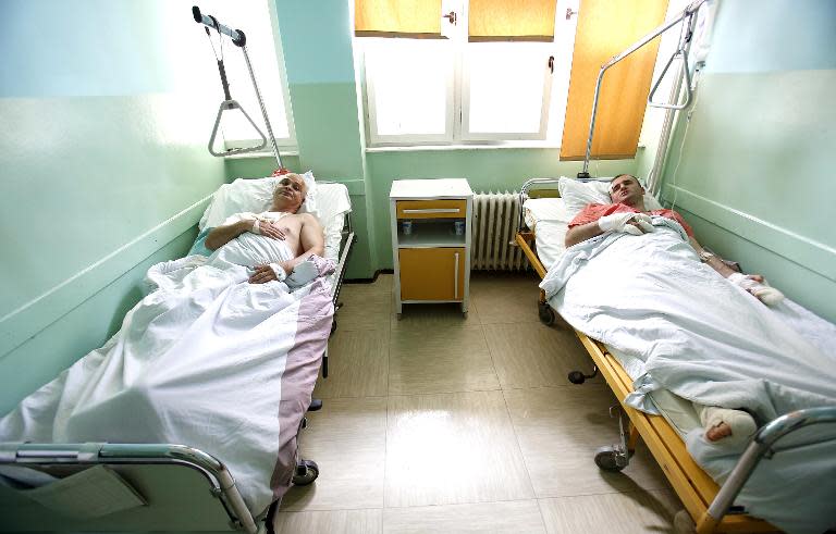 Bosnian policemen Stevo Milovanovic and Zeljko Gajic lie in their hospital beds in eastern Bosnia town of Zvornik, on April 28, 2015, a day after an attack at their police station in the town of Zvornik