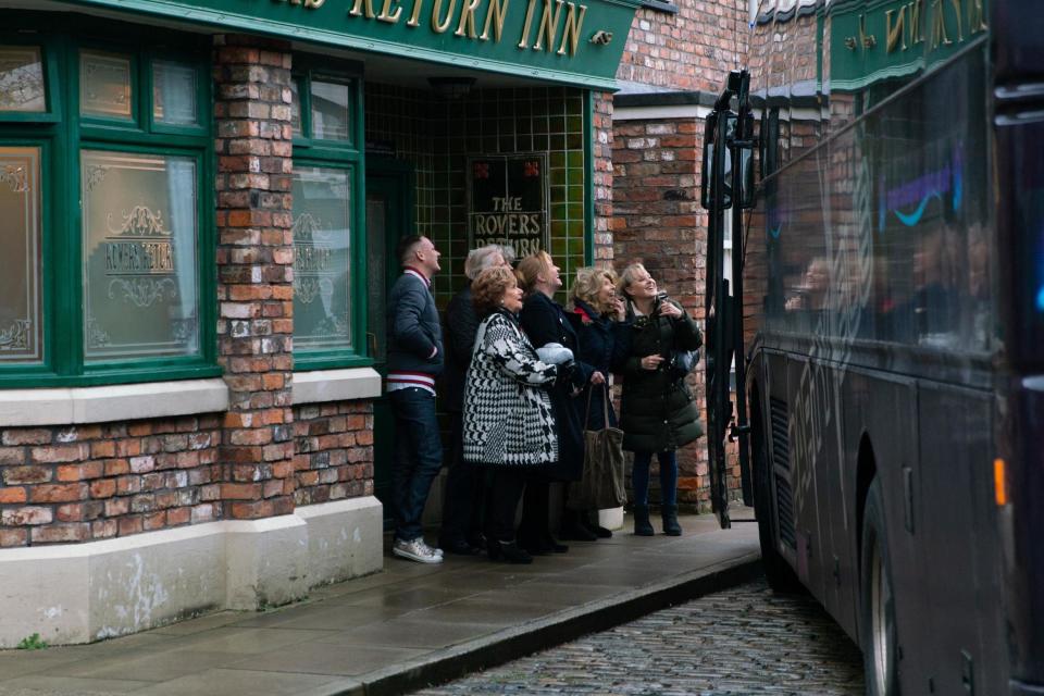 Coronation Street characters waiting to board a bus to Blackpool in the soap's 10,000th episode (PA)