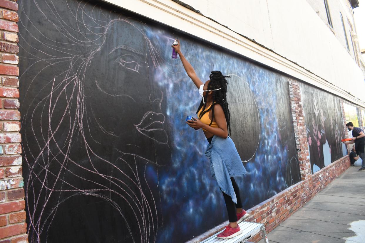 Takiya Jones of Alexandria is making a statement with the first mural she has ever painted. "This piece is called 'Unity,'" said the 26-year-old. She and other artists were painting live during Alex RiverFete held Friday and Saturday in downtown Alexandria.