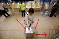 A voter casts a ballot at a voting station during Japan's upper house election in Tokyo