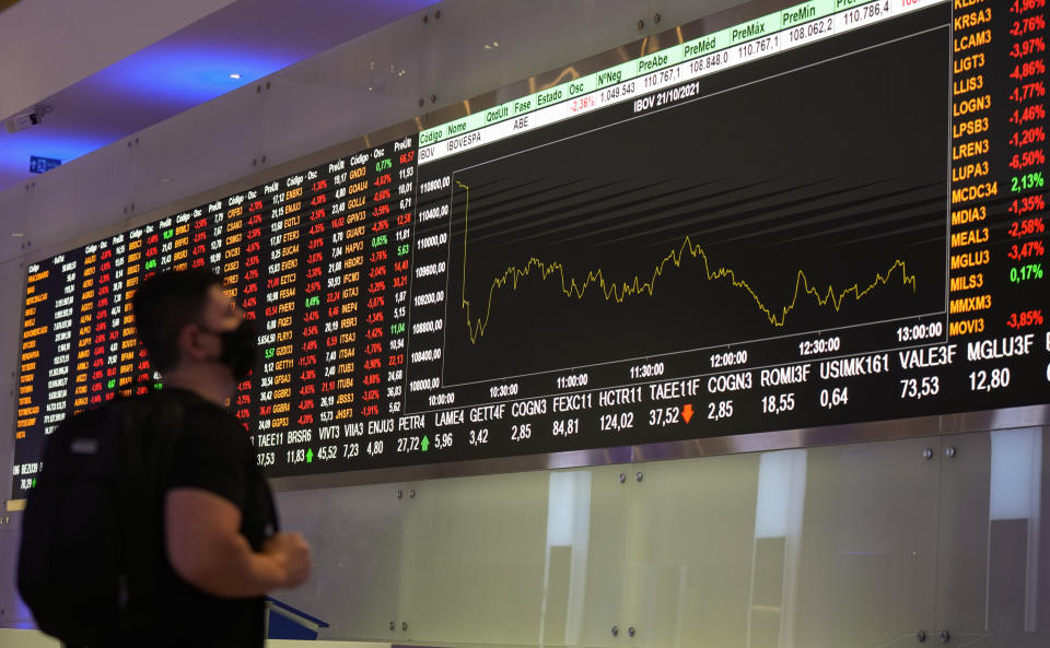 FILE - A visitor looks at stock price monitors at the B3 stock exchange headquarters in Sao Paulo, Brazil, Oct. 21, 2021. According to a study released Thursday, April 11, 2024, voters in 19 countries, including in three of the world’s largest democracies, are widely skeptical about whether their elections are free and fair, and many favor a strong, undemocratic leader. (AP Photo/Andre Penner, File)