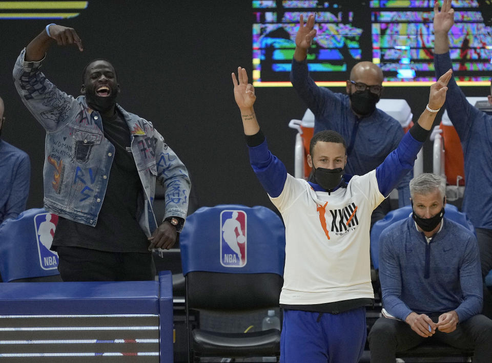 Golden State Warriors' Draymond Green, left, and Stephen Curry, front right, celebrate after Jordan Poole scored a three-point basket against the New Orleans Pelicans during the first half of an NBA basketball game on Friday, May 14, 2021, in San Francisco. (AP Photo/Tony Avelar)