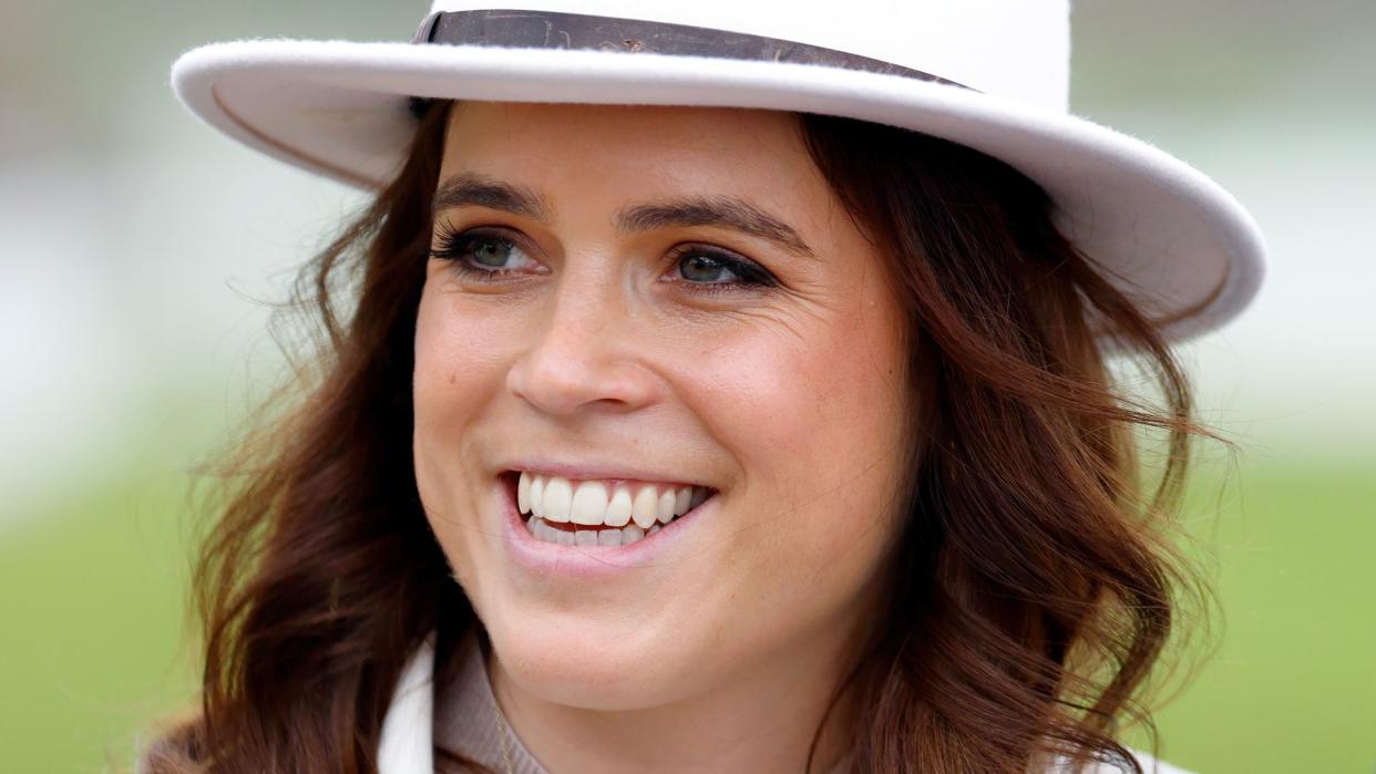 Princess Eugenie wearing a white hat at The Cheltenham Festival