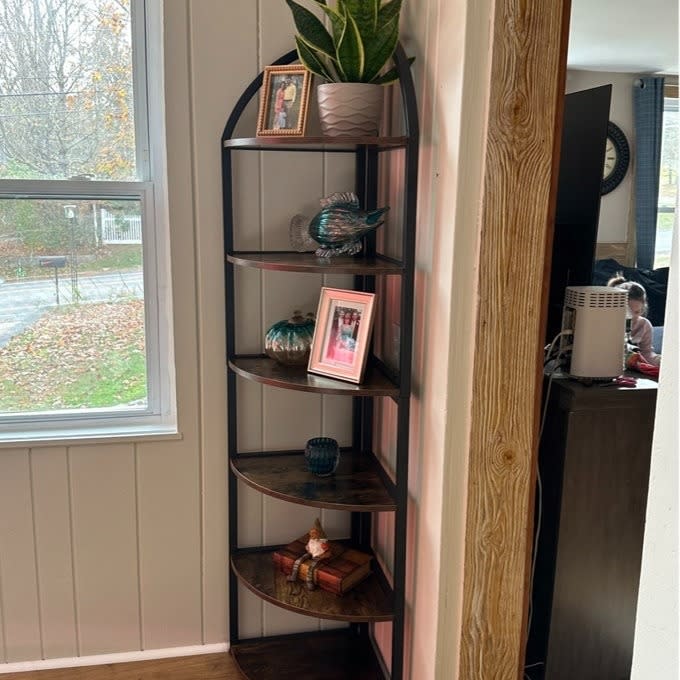 the corner shelf in a home with trinkets on it