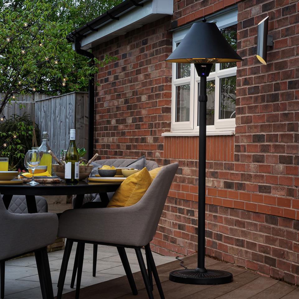 Zanussi 2100W Black Adjustable Freestanding Patio Heater in a garden with tables and chairs