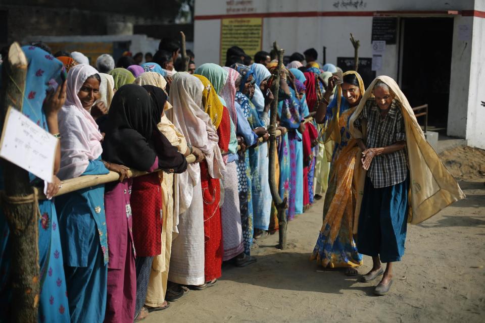 An elderly Indian voter is helped by a woman after coming out a polling booth in Shahbazpur Dor village in Amroha, in the northern Indian state of Uttar Pradesh, Thursday, April 17, 2014. Indians cast ballots Thursday on the biggest day of voting in the country's weekslong general election, streaming into polling stations even in areas where rebels threatened violence over the plight of India's marginalized and poor. (AP Photo/Altaf Qadri)