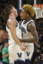 Villanova guard Collin Gillespie, left, and guard Justin Moore chest bump after Moore made a three point shot during the second half of an NCAA college basketball game against Marquette, Wednesday, Jan. 19, 2022, in Villanova, Pa. (AP Photo/Laurence Kesterson)