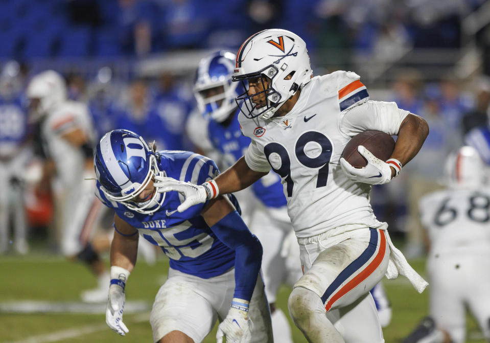 Virginia's Keytaon Thompson (99) carries the ball past Duke's Cam Dillon (35) during the first half of an NCAA college football game in Durham, N.C., Saturday, Oct. 1, 2022. (AP Photo/Ben McKeown)