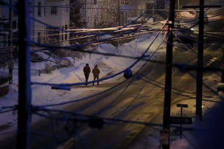 Pedestrians make their way through a winter snow storm in Medford, Massachusetts, U.S. February 12, 2017. REUTERS/Brian Snyder