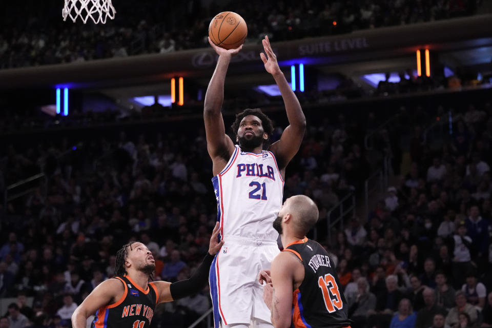 Philadelphia 76ers center Joel Embiid (21) shoots over New York Knicks guard Evan Fournier (13) during the first half of an NBA basketball game, Sunday, Feb. 5, 2023, in New York. (AP Photo/John Minchillo)