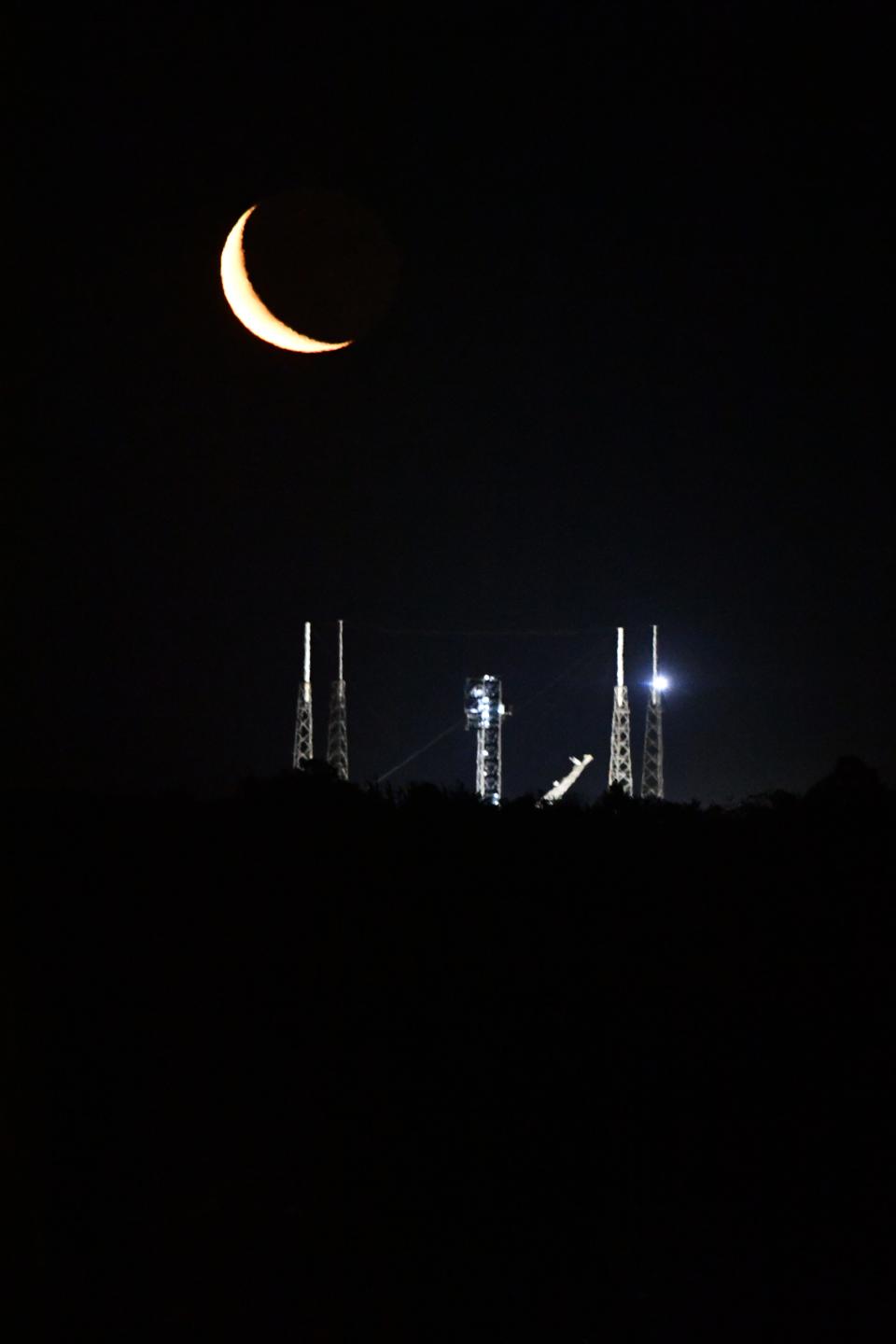 The crescent moon rises over Launch Complex 40 at Cape Canaveral Space Force Station after Friday's early morning liftoff of a SpaceX Falcon 9 rocket.