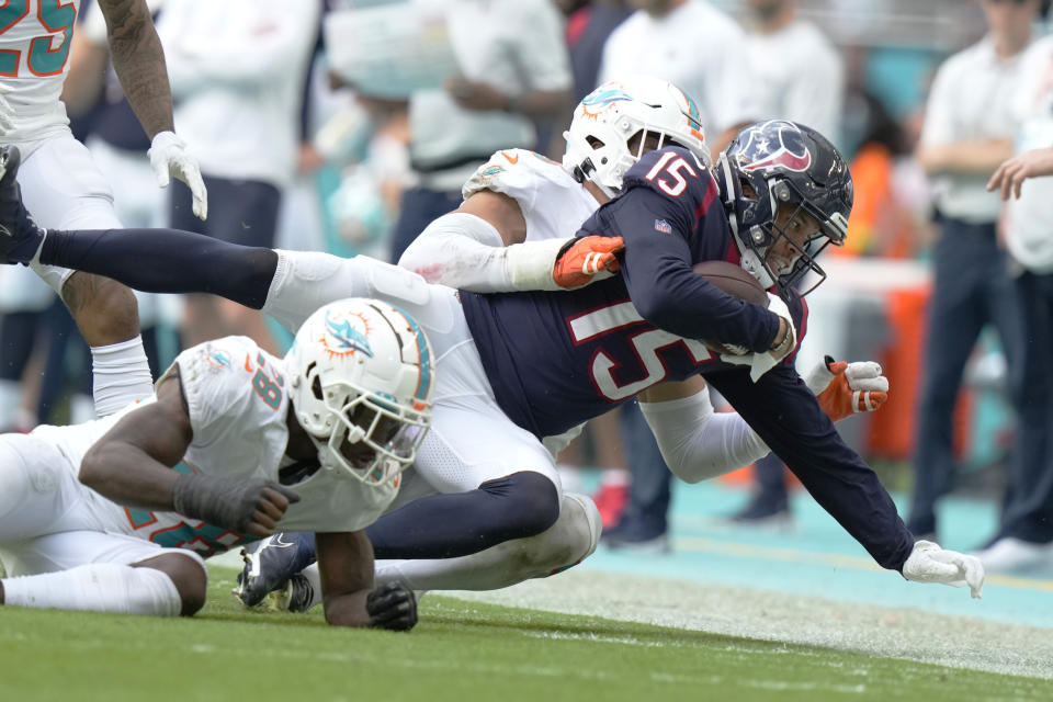 Miami Dolphins linebacker Jaelan Phillips (15) tackles Houston Texans wide receiver Chris Moore (15) during the second half of an NFL football game, Sunday, Nov. 27, 2022, in Miami Gardens, Fla. (AP Photo/Lynne Sladky)
