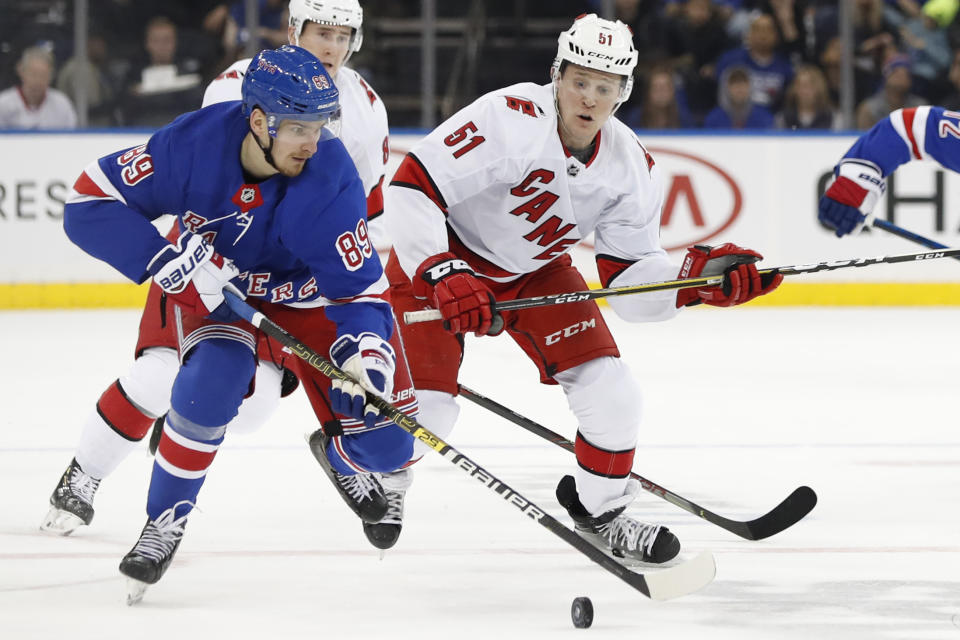 Carolina Hurricanes defenseman Jake Gardiner (51) chases New York Rangers right wing Pavel Buchnevich (89) during the second period of an NHL hockey game Friday, Dec. 27, 2019, in New York. (AP Photo/Kathy Willens)