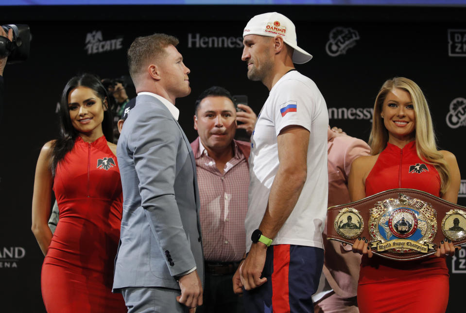 Sergey Kovalev, center right, and Canelo Alvarez pose for photographers during a news conference Wednesday, Oct. 30, 2019, in Las Vegas. The two are scheduled to fight in a WBO light heavyweight title bout Saturday in Las Vegas. (AP Photo/John Locher)