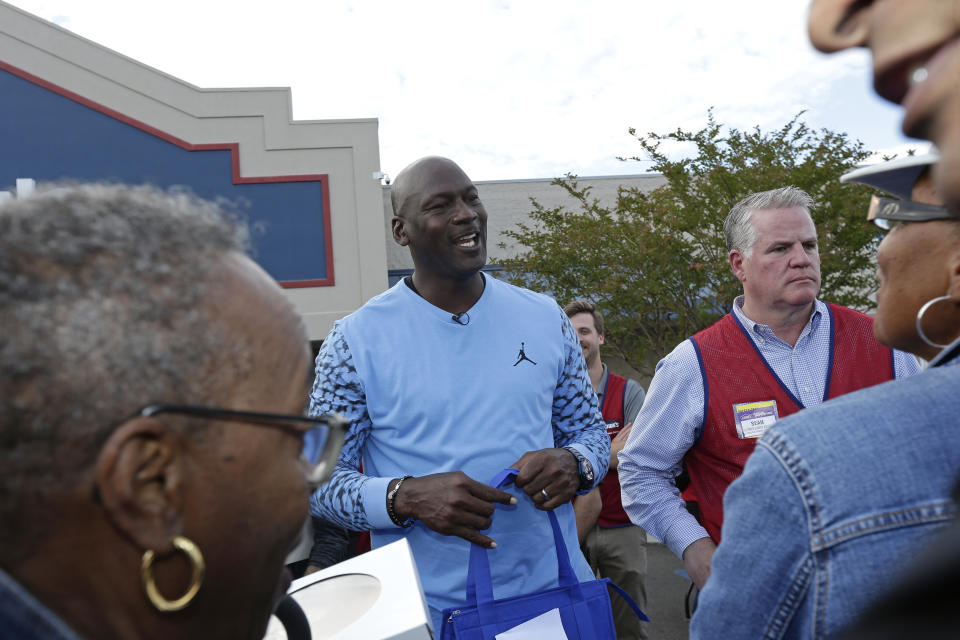 Charlotte Hornets owner Michael Jordan greets people and hands out Thanksgiving food to members of the community in Wilmington, N.C., Tuesday, Nov. 20, 2018. (AP Photo/Gerry Broome)