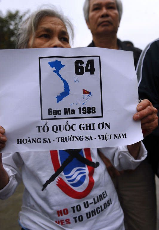 An elderly anti-China protester in Hanoi holds a poster remembering the 64 Vietnamese sailors killed March 14, 1988 during a Sino-Vietnam naval battle at Gac Ma island in the contested Spratly Islands