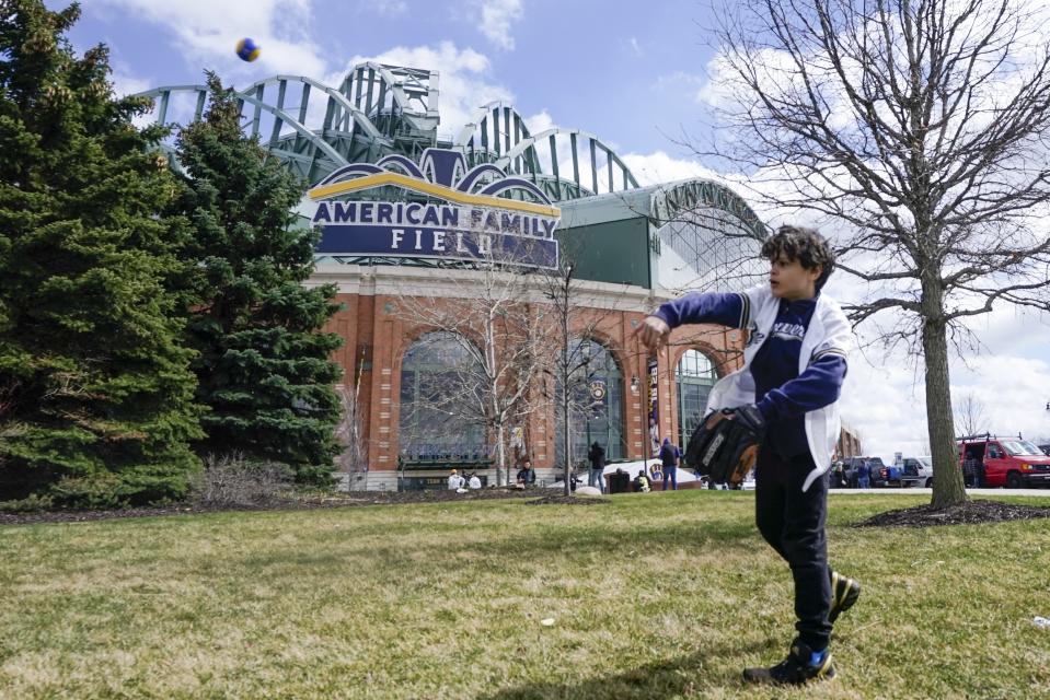 FILE - Lennon Jones plays catch outside American Family Field before the Milwaukee Brewers' home opener against the St. Louis Cardinals, April 14, 2022, in Milwaukee. Wisconsin Gov. Tony Evers' office announced Tuesday, Feb. 14, 2023, that he wants to hand the Milwaukee Brewers nearly $300 million from Wisconsin's budget surplus to enact repairs and renovations on American Family Field. (AP Photo/Morry Gash, File)