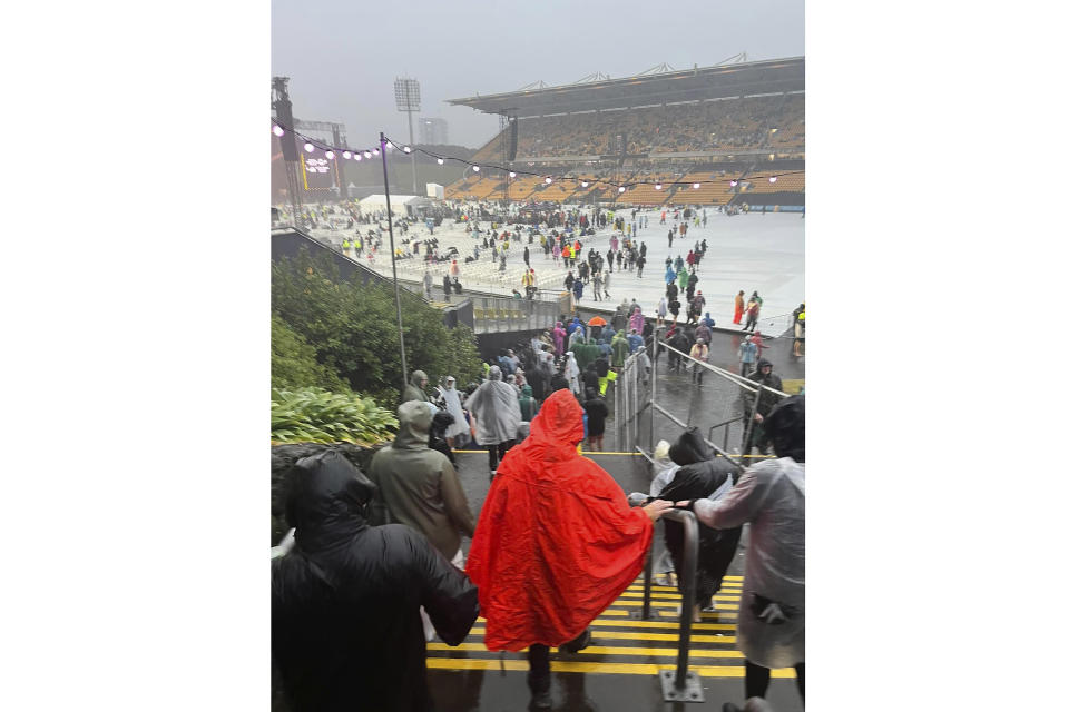 Fans leave Mt Smart Stadium in Auckland, New Zealand, Friday, Jan. 27, 2023, where about 40,000 people were expected to attend an Elton John concert. Torrential rain and wild weather in Auckland causes disruptions throughout the city and an Elton John concert to be canceled just before it was due to start. (Julea Dalley/New Zealand Herald via AP)