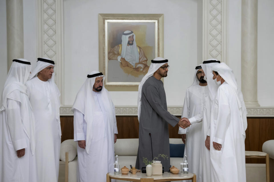 This photo from Ministry of Presidential Affairs shows Sheikh Mohamed bin Zayed Al Nahyan, President of the United Arab Emirates and Ruler of the Emirate of Abu Dhabi, 4th left, shakes hands with one of the rulers in the presence of the Sheikh Mohammed bin Rashid Al Maktoum, Vice President, Prime Minister and Ruler of Dubai, 3rd right, Dr. Sheikh Sultan bin Muhammad Al Qasimi, Supreme Council Member and Ruler of Sharjah, 3rd left, and rest of UAE rulers, as Mohamed bin Zayed accepts their condolences, Saturday, May14, 2022. (Ministry of Presidential Affairs via AP/Hamad Al Kaabi)