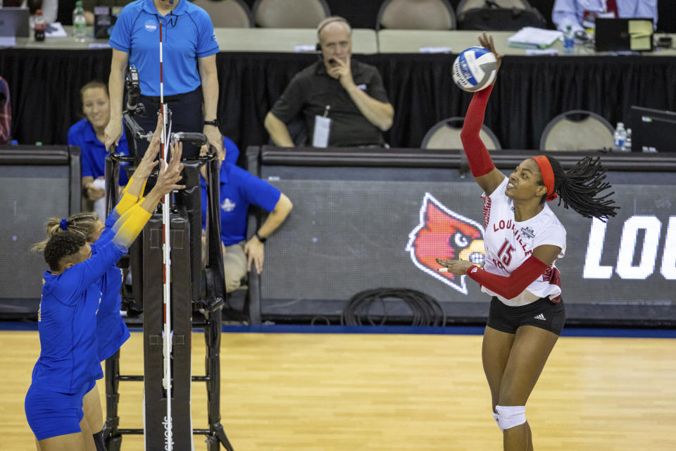 Louisville's Aiko Jones (15) spikes the ball against Pittsburgh's Rachel Fairbanks (10) and Serena Gray (21) in the second set during the semifinals of the NCAA volleyball tournament, Thursday, Dec. 15, 2022 in Omaha, Neb. (AP Photo/John S. Peterson)