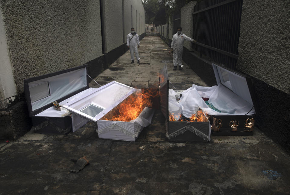 Crematorium workers burn the coffins of COVID-19 victims after they have been cremated at the San Nicolas Tolentino cemetery in the Iztapalapa neighborhood of Mexico City, Wednesday, June 24, 2020. (AP Photo/Marco Ugarte)