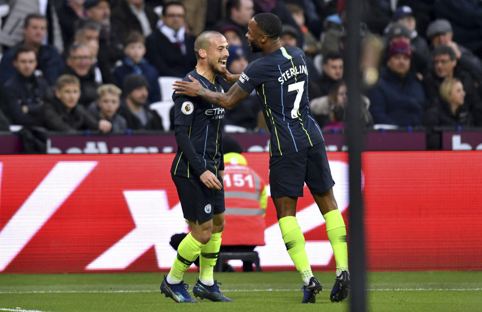 Manchester City's David Silva, left, celebrates scoring his side's first goal of the game with team mate Raheem Sterling during their English Premier League soccer match against West Ham United at The London Stadium, London, Saturday, Nov 24, 2018. (Dominic Lipinski/PA via AP)