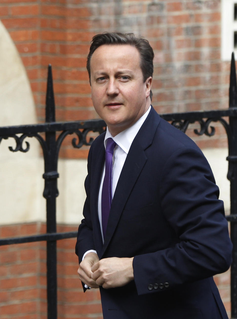 British Prime Minister David Cameron arrives to give evidence at the Leveson inquiry at the Royal Courts of Justice in central London, Thursday, June 14, 2012. The judge-led inquiry was set up following revelations of phone hacking at Murdoch's News of the World tabloid. The scandal has shaken the British establishment and raised questions about whether top politicians helped shield Murdoch from scrutiny. (AP Photo/Lefteris Pitarakis)