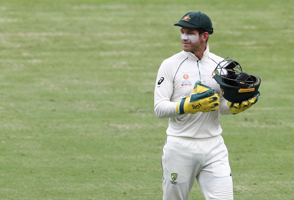 Australia's Tim Paine carries a helmet during play on day two of the fourth cricket test between India and Australia at the Gabba, Brisbane, Australia, Saturday, Jan. 16, 2021. (AP Photo/Tertius Pickard)