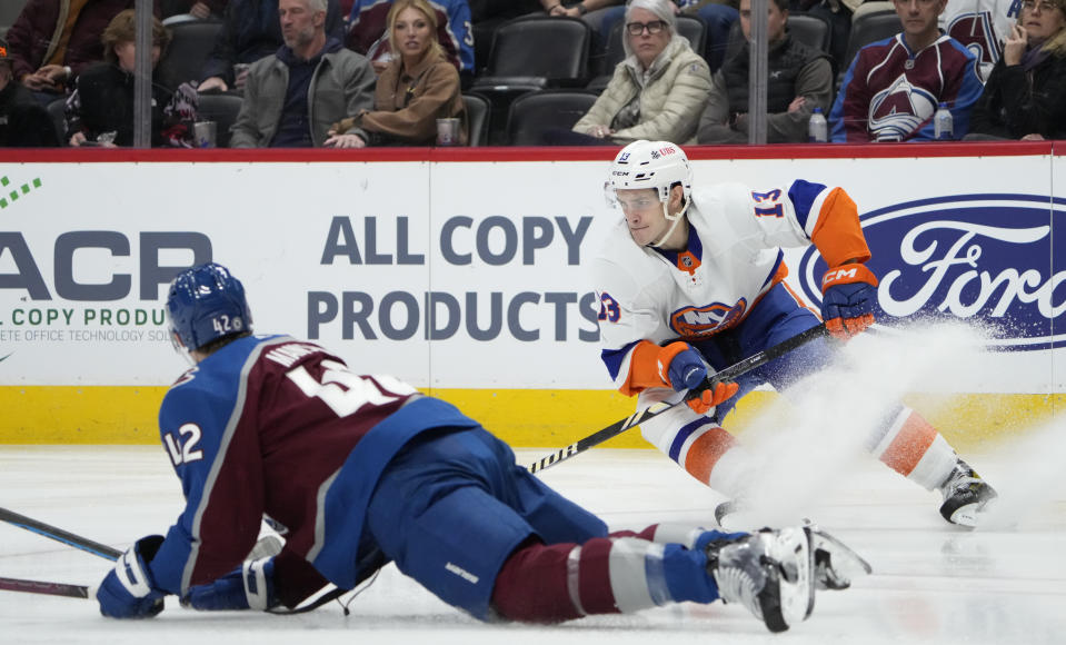 Colorado Avalanche defenseman Josh Manson, front, attempts to block a shot by New York Islanders center Mathew Barzal during the second period of an NHL hockey game Tuesday, Jan. 2, 2024, in Denver. (AP Photo/David Zalubowski)