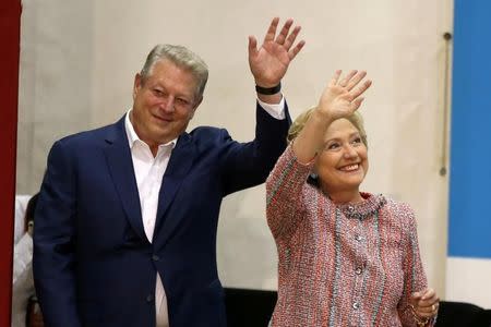 U.S. Democratic presidential nominee Hillary Clinton (R) and former Vice President Al Gore wave at a rally at Miami Dade College in Miami, Florida, U.S. October 11, 2016. REUTERS/Lucy Nicholson
