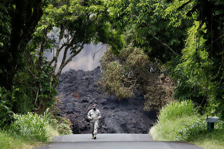 Lieutenant Colonel Charles Anthony, of the Hawaii National Guard, measures sulfur dioxide gas levels at a lava flow on Highway 137 southeast of Pahoa during ongoing eruptions of the Kilauea Volcano in Hawaii, U.S., May 20, 2018. REUTERS/Terray Sylvester